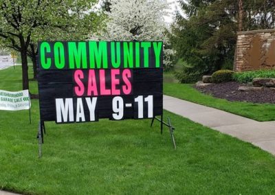 Community Garage Sales advertised with big black signs with neon letters