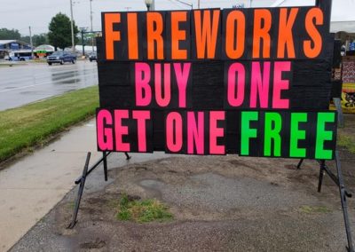 Those neon letters on a black sign sell fireworks